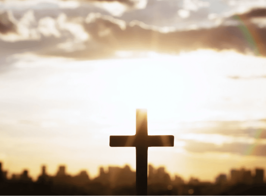 Sunrise and rainbow over a cross
