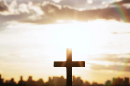 Sunrise and rainbow over a cross