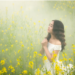 Woman praying in a field of yellow flowers