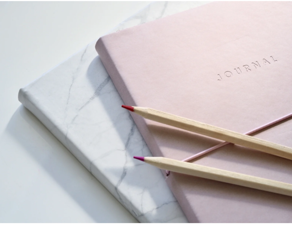 Picture of two journals with two pencils on top