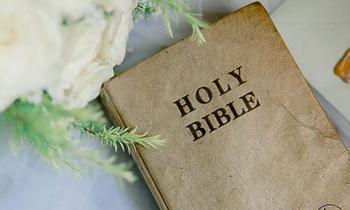Bible next to white flowers