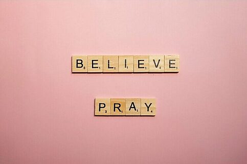 Believe and pray written in scrabble pieces