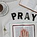 Word Pray spelled out, two Bibles, and a cup of tea