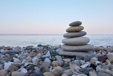 stack of rocks by body of water as analogy for strengthening faith