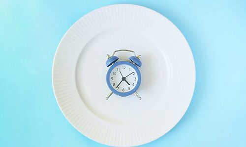 Empty plate with clock on it illustrate fasting