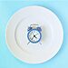 Empty plate with clock on it illustrate fasting