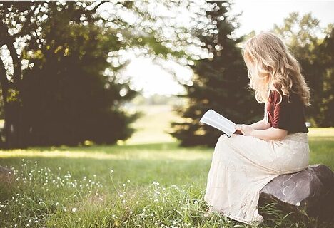 Woman outside reading Bible illustrate fasting and reading Bible to hear from God
