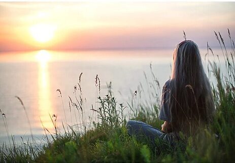 Picture of woman sitting by lakefront as part of hearing God’s voice by cultivating peace