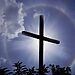 Cross with halo around it under a dark sky