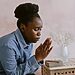Woman praying near Bible illustrates submitting to God through prayer