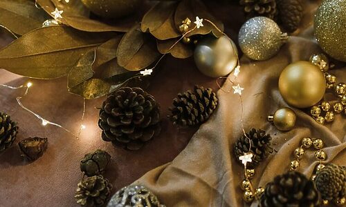 Acorns, gold garland, and Christmas ornaments represent Christmas time