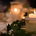 White candles on table with greenery illustrate finding God’s peace during stressful Christmas season