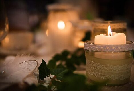 White candles on table with greenery illustrate finding God’s peace during stressful Christmas season