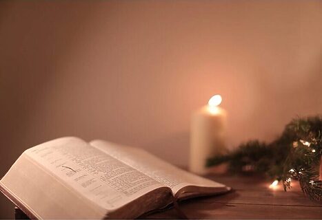 Bible opened to book of Psalms next to candle and greenery illustrate Bible verses about contentment