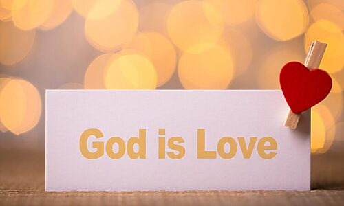 Placard that says “God is love” with decorative heart attached by clothespin illustrates God’s love for you