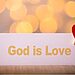 Placard that says “God is love” with decorative heart attached by clothespin illustrates God’s love for you