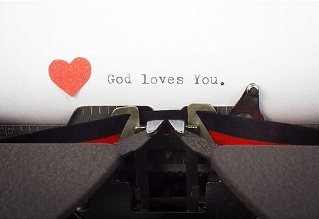 Typewriter with typewritten message that says “God loves you” with a heart illustrates God’s love