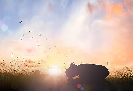 Woman praying on knees during sunrise illustrates being in God’s presence as part of God’s love for you