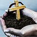 Image of woman holding a cross in a patch of dirt illustrates growing faith in 2025