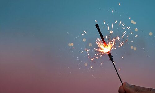 Image of hand holding a sparkler illustrates Prayer for God’s Vision in 2025