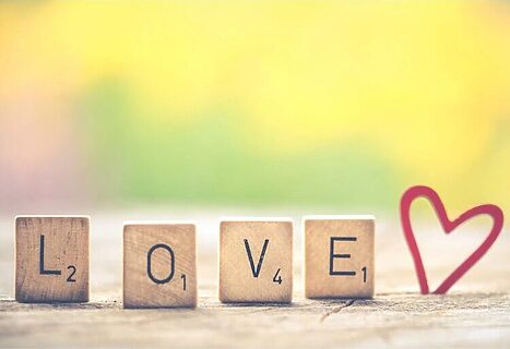 Image of love spelled out with scrabble pieces next to heart illustrate God’s Love for us