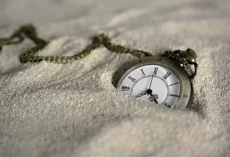Image of watch covered in sand represent trusting God’s timing
