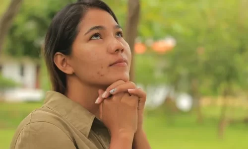 Image of woman looking up in hopeful prayer represents waiting on God and relying on God’s timing