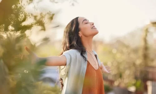 Woman with outstretched arms and closed eyes represents waiting on God and trusting in Him