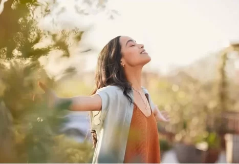Woman with outstretched arms and closed eyes represents waiting on God and trusting in Him