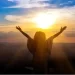 Woman enjoying sunrise with outstretched hands represent hope while waiting on God